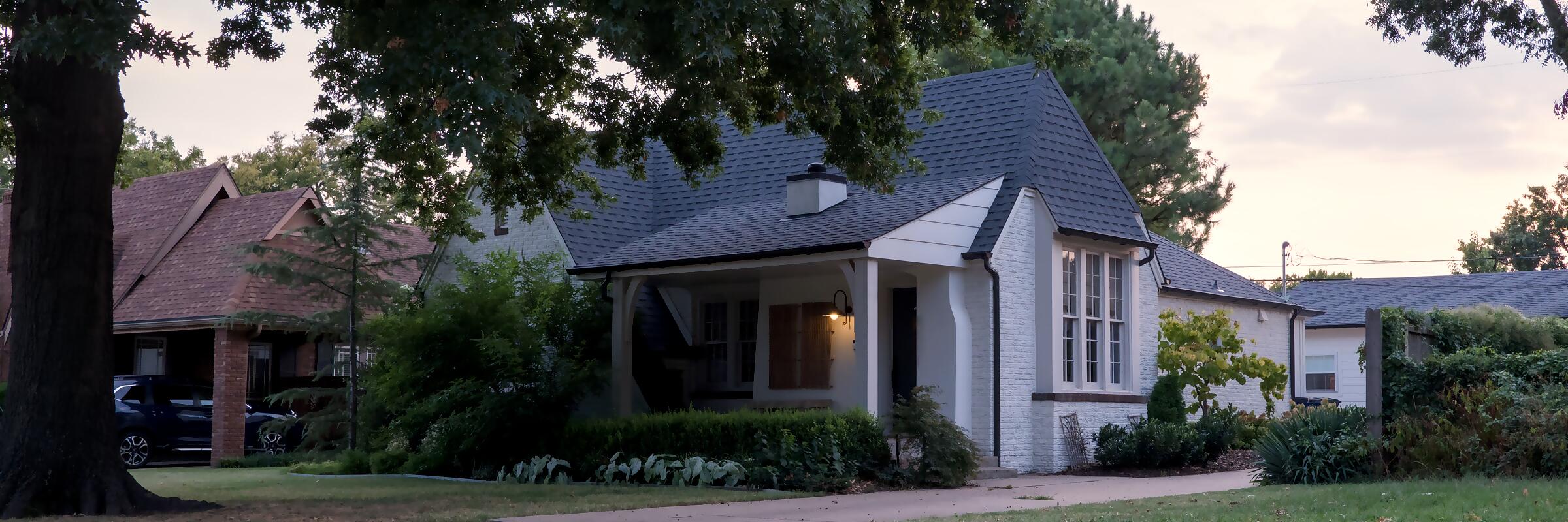 A Tulsa home at dusk with the porch light on